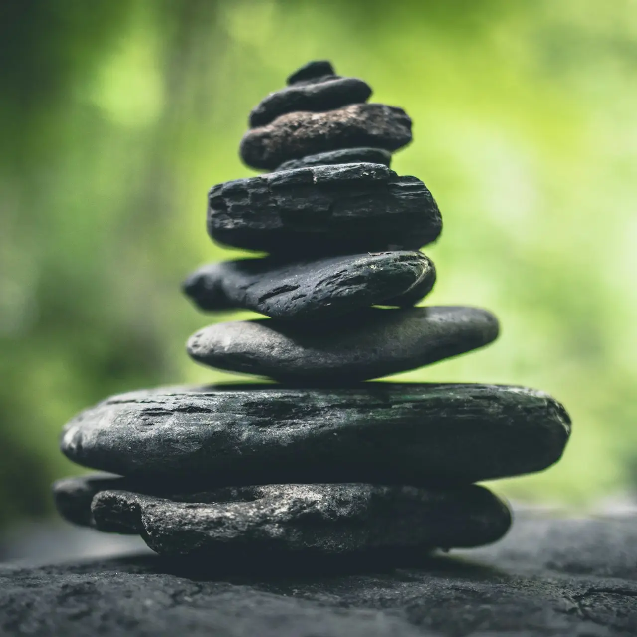 black stacking stones on gray surface